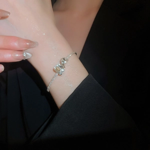 Elegant silver chain bracelet featuring dual heart-shaped zircons on a delicate wrist
