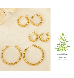 Detailed close-up of three sizes of polished gold hoop earrings with secure hinge clasp