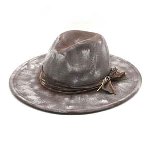 Detail of distressed brown wool felt fedora featuring vintage leather band and weave