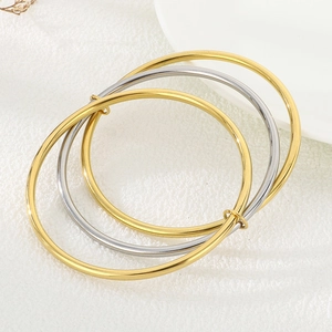 Detailed view of three-piece interlocking stainless steel bangles with sliding rings