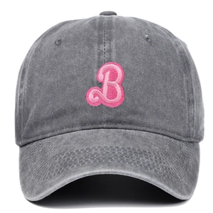 Close-up of pink embroidered B letter on washed grey cotton baseball cap with ventilation holes