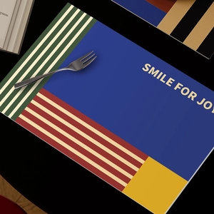 Waterproof leather placemat with colorful patchwork design and Smile for Joy text