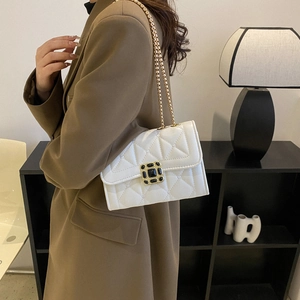 Elegant white quilted crossbody bag with gold chain strap and black gemstone clasp