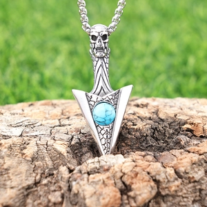 Gothic punk silver skull arrow pendant necklace with blue turquoise on wooden surface