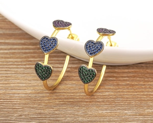 Macro shot of 18k gold plated hoop earrings with three colorful zircon heart charms