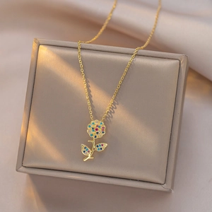 Elegant gold rose necklace with colorful zircons on a luxury champagne jewelry gift box