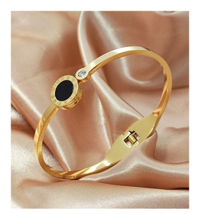 Detailed macro view of the Roman numerals engraving and black shell inlay on the golden bangle
