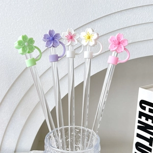 Detailed set of five colorful cherry blossom silicone straw covers on glass straws