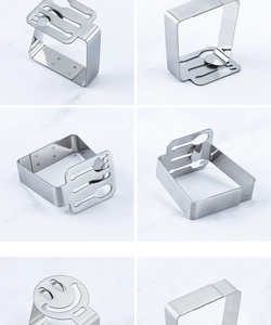 Detailed view of leaf shaped stainless steel tablecloth clip on marble surface