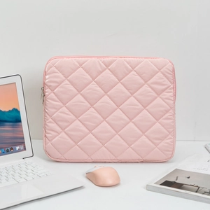 Detailed view of pink quilted laptop sleeve with diamond pattern and matching zipper