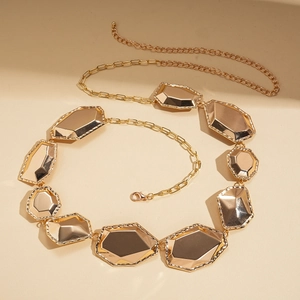 Detailed close-up of golden metallic waist chain with geometric faceted plates