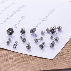 Set of 12 punk gothic stainless steel skull and flower screw back ear studs on vintage paper