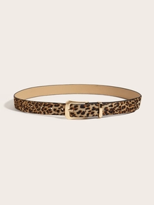 Detail of leopard print belt with gold square pin buckle and metal loop on beige background