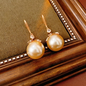 Élégantes boucles d'oreilles pendantes en perles dorées avec détails en zircon brillant