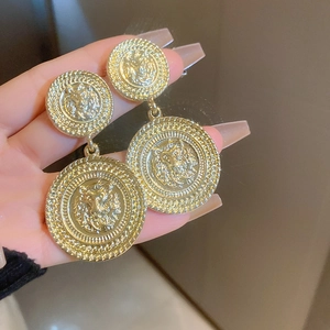 Macro view of gold lion head relief earrings in vintage baroque style for women