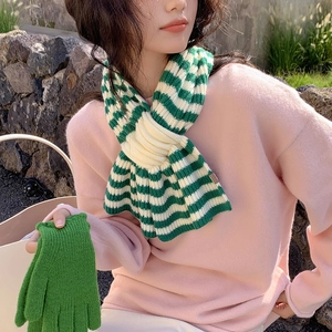 Winter striped knit scarf and matching green gloves set worn by a model in outdoor setting
