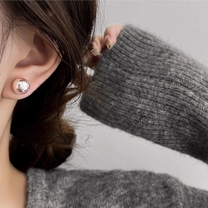 Rose gold round pearl stud earrings for women shown worn on ear for elegant style