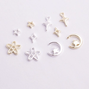 Close-up of gold and silver alloy star and moon nail art charms for DIY jewelry designs