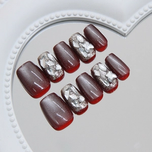 Handmade burgundy cat eye press-on nails with luxury rhinestones on a heart mirror