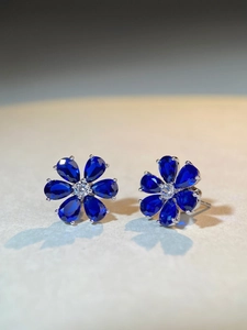 Macro shot of S925 silver flower stud earrings with blue teardrop stones and zircon