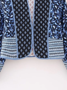 Detail of bohemian quilted jacket featuring paisley print and curved hemline