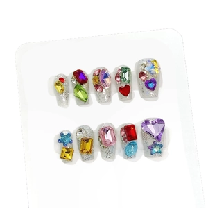 Sparkly silver press-on nails set with colorful gemstone crystals and glitter finish