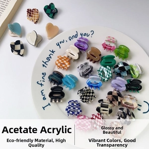 Mini acetic acid hair clips in diverse checkered and marble patterns displayed on a plate