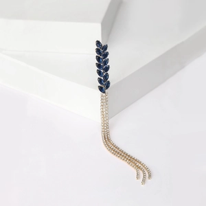 Macro view of blue rhinestone wheat ear stud earring with hanging golden tassels