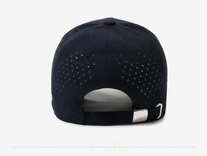 Detail of navy blue baseball cap featuring laser-cut ventilation holes and metal buckle