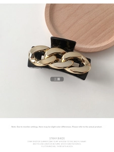 Detail of Korean style square hair claw clip with golden chain link on black resin surface