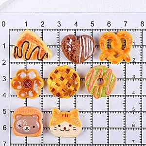 Flat lay of assorted resin food miniatures on a centimeter scale cutting mat