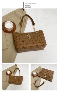 Detail of yellow-brown tote bag featuring vintage pattern and golden deer charm