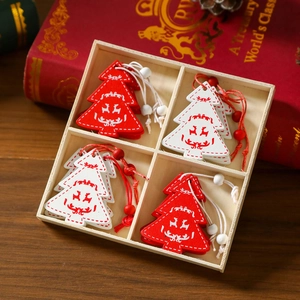 Sammlung von roten und weißen Weihnachtsbaumanhängern aus Holz in einer Geschenkbox