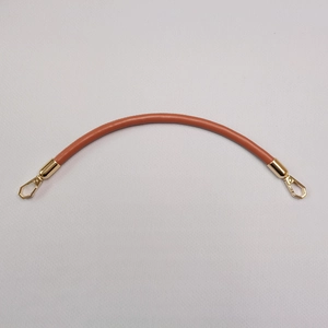 Detailed close-up of brown leather bag handle with premium gold metal clasps