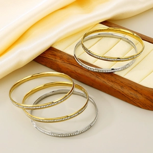 Stackable gold and silver titanium steel bangles with pavé crystal inlay 5.5mm wide