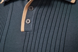 Detail of dark green knit polo sweater with contrasting khaki placket and ribbed texture