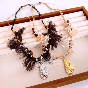 Ethnic woven cotton rope necklace with seashell pendant and tassels in a jewelry box