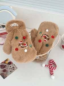 Gros plan de mitaines en peluche marron avec broderie de chiot de Noël festive