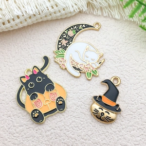 Detail of Halloween charms featuring black cat in pumpkin and cat on moon pendants