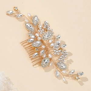 Elegant bridal hair comb with gold wire, crystals, and pearls on a soft lace background