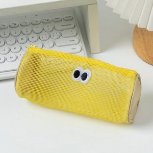 Cute yellow mesh cylindrical pencil case with embroidered eyes on white desktop