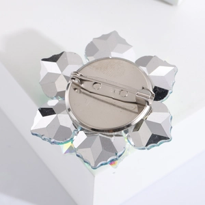 Macro shot of the polished silver alloy back structure and safety pin of a floral brooch