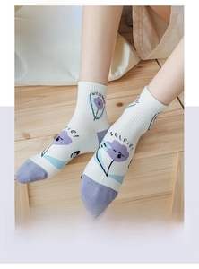 Détail de chaussettes en coton blanc avec motifs floraux violets et talons colorés
