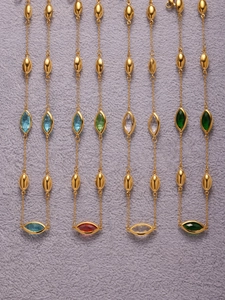 Detail of 18k gold plated necklaces with marquise gemstones and olive metal beads