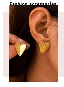 Detailed macro view of gold heart-shaped leaf earrings with textured metal finish