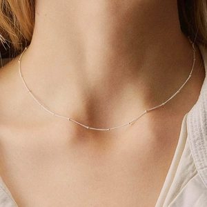 Minimalist silver bead chain necklace worn by model showing elegant neck jewelry style