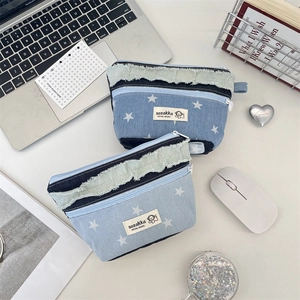 Detail of patchwork denim coin purses with white star patterns and green frayed edges