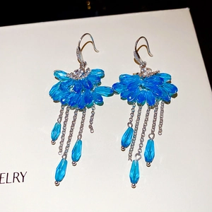 Detail of blue fan-shaped crystal tassel earrings with zircon studs and teardrop pendants