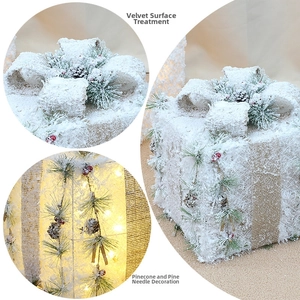 Detail showing white flocked surface with pine cones and LED lights on Christmas gift box