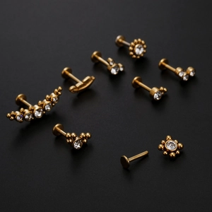 Titanium steel gold labret piercing set with sparkling round zircon crystals on black surface